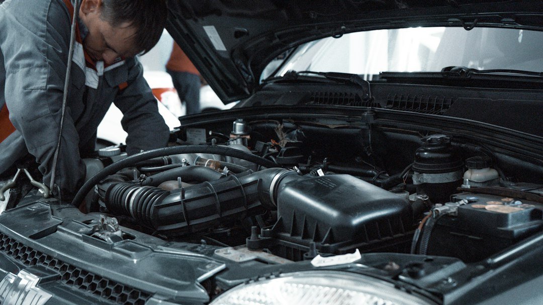 Mechanic inspecting a car engine in a workshop